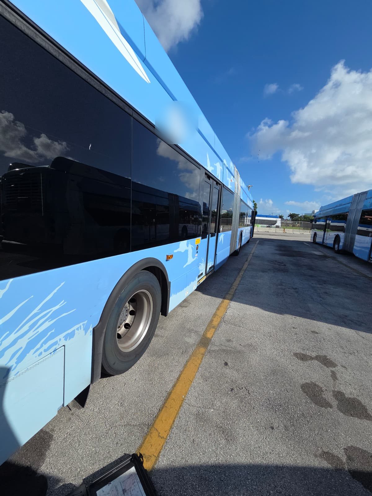 Articulated electric transit bus parked in a depot yard