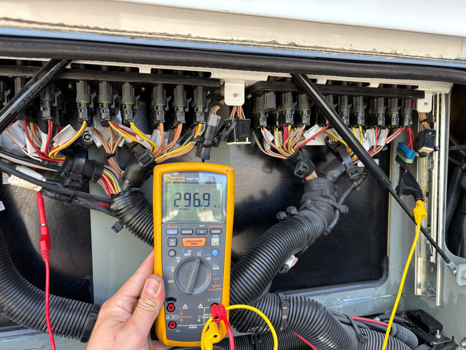 Fluke insulation multimeter reading 296.9 kilohms in front of the connector panel
