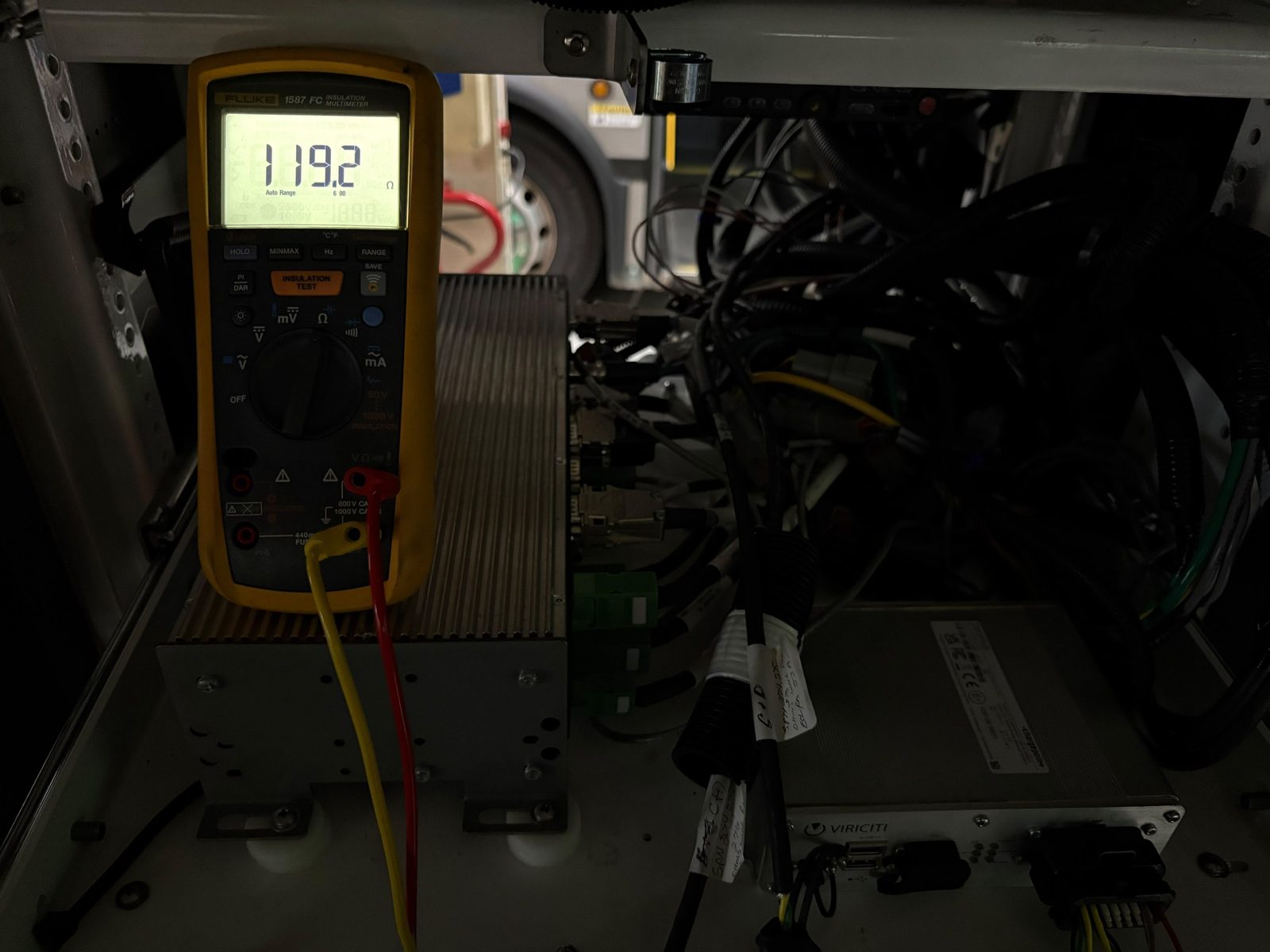 Multimeter reading 119.2 ohms on a vehicle network next to the telematics unit